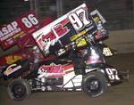 Aaron Berryhill (97) and Jason Johnson (41) split a lapped car while battling for the lead with less than two laps to go in Saturday night's 30-lap O'Reilly American Sprint Cars on Tour National feature event at Missouri's Lake Ozark Speedway.